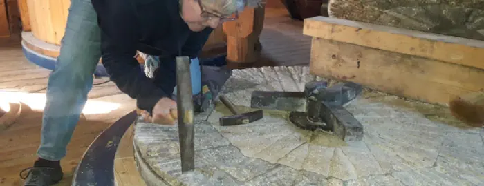 Ein Mahlstein wird gepickelt