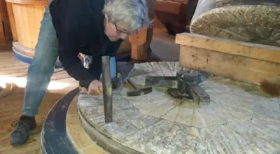 Ein Mahlstein wird gepickelt
